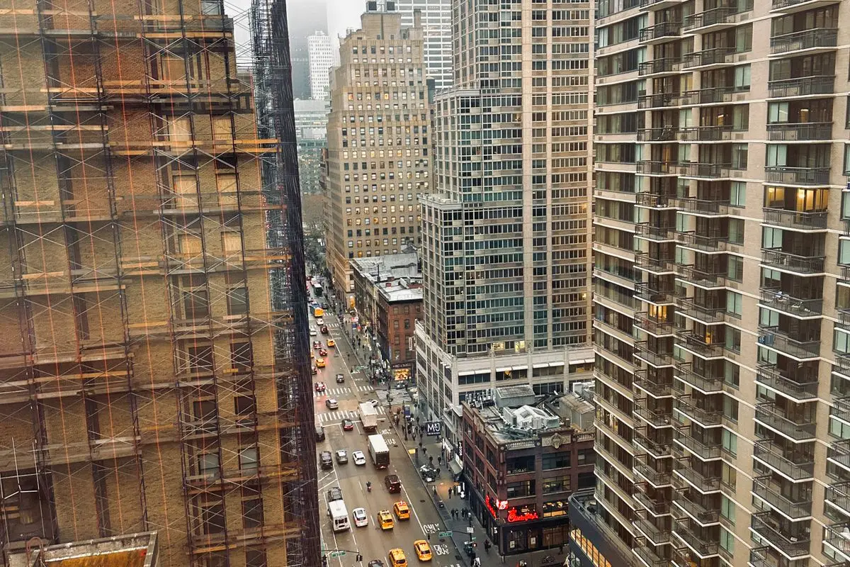 Manhattan buildings with scaffolding above a busy avenue