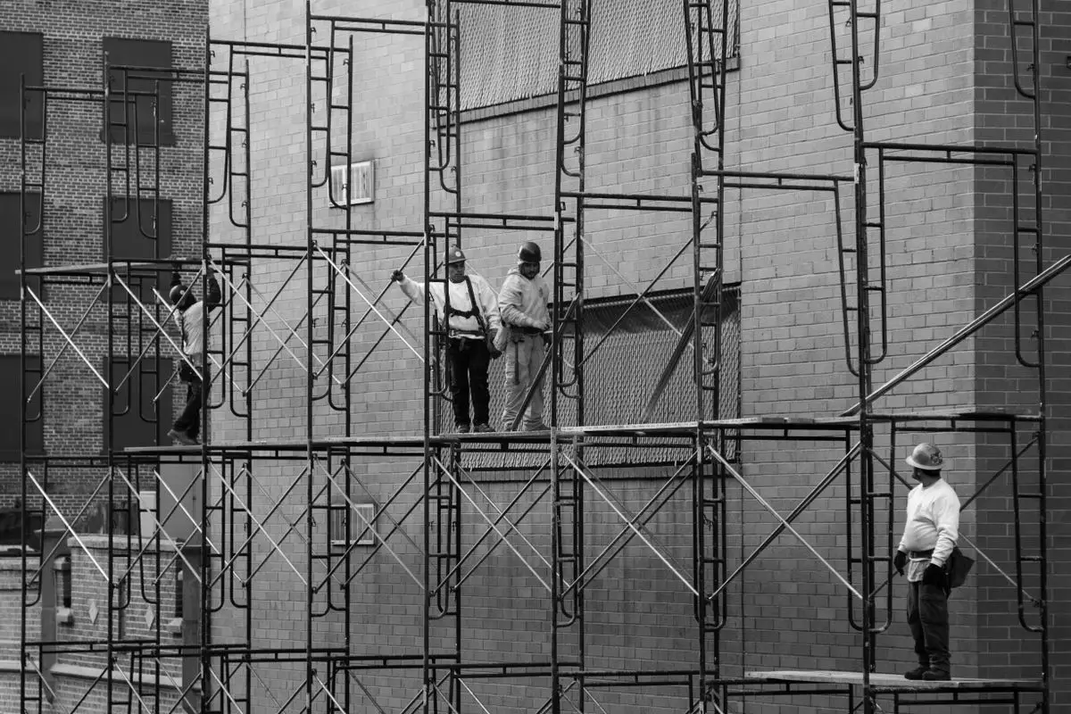 Workers on scaffolding repairing a building facade in New York