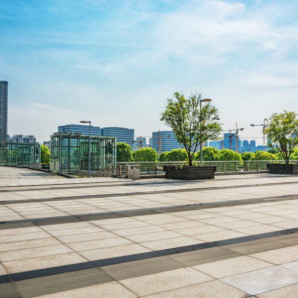 long empty footpath in modern city square with skyline.